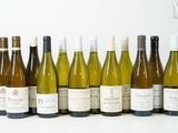 plusieurs bouteilles de vin sont alignées sur une surface blanche