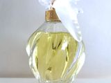 a bottle of perfume with a white bow on top of it