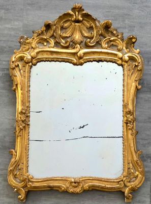 un miroir accroché au mur, avec un cadre doré