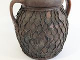 un vase brun posé sur une surface blanche