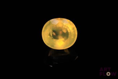 un gros plan d'une boule de cristal jaune posée sur une surface noire