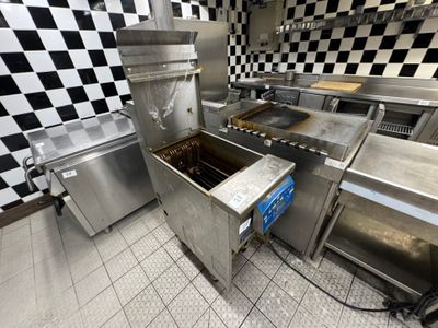 une cuisine avec un mur à carreaux et des appareils électroménagers en inox