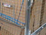 a metal cage with boxes in it on a cart