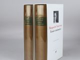 two books sitting on top of each other in front of a white box