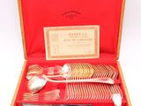 a set of silverware in a wooden box with a red case
