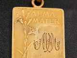 a close up of a gold plated pendant with a tree on it