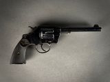 un pistolet posé sur une table, sur fond gris