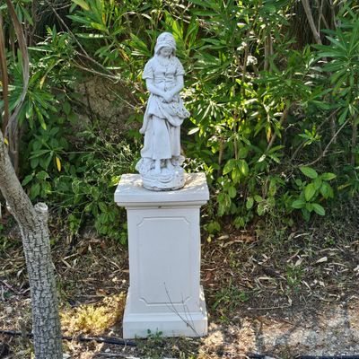une statue de femme tenant un enfant sur un piédestal