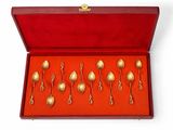 un lot de six cuillères en or dans un coffret rouge