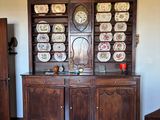 a wooden china cabinet in the middle of a room