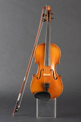 an old violin with a bow and bow rest on a stand