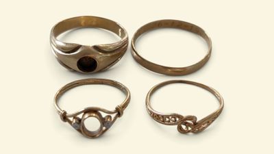 three rings with a stone in the middle of them on a white surface