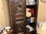 a wooden cabinet in the corner of a bedroom