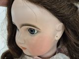 a doll that has a pink ribbon on it ' s head