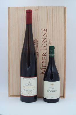 deux bouteilles de vin posées devant une caisse en bois sur une table