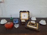 une table sur laquelle se trouvent un cadre photo, des tasses à thé et d'autres objets