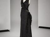 une robe noire posée sur un mannequin dans une pièce blanche