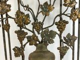 a metal gate with a vase on top of it