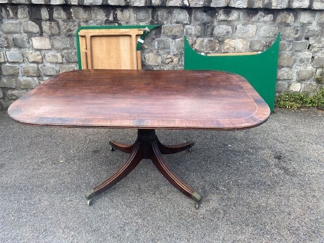 Une table de salle à manger en acajou et plaquage acajou elle repose sur des pieds cintrés Travail Anglais du XIXème ...