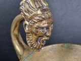 a close up of a gold cup with a face on it