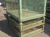 une cage verte posée au sommet d'une pile de palettes