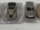three toy cars sitting in plastic containers on a table