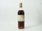 une vieille bouteille de whisky posée sur une table blanche