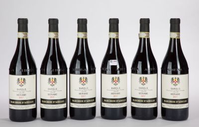 six bouteilles de vin sont alignées sur une surface blanche
