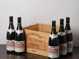 six bouteilles de vin posées sur une table à côté d'une caisse de vin
