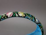 a close up of a bracelet with flowers on it