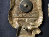 two old brass objects on a black surface