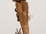 a wooden sculpture with a bird on top of it
