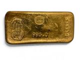 a gold bar on a white surface with a white background