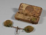 a small wooden box with a wooden spoon and a pair of gold spoons