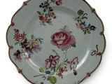 a plate with a floral design on it on a stand