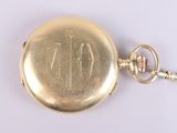 a gold pocket watch with a chain on a white surface