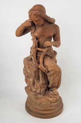 statue représentant une femme assise sur un rocher, tenant un oiseau dans la main