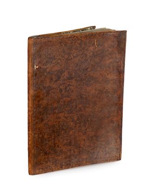 an old book with a brown leather cover on a white background