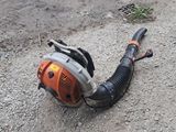 a small blower sitting on the ground next to a hose