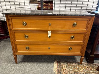 une commode ancienne avec un plateau en marbre et des poignées en laiton