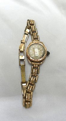 une image d'une montre-bracelet en or avec des chiffres romains