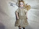 a doll that is sitting on a white surface