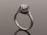 a close up of a diamond ring on a reflective surface