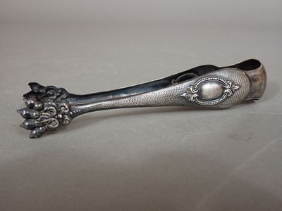 silver spoon with flowers on it sitting on a white surface