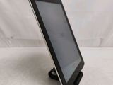 the tablet is sitting on a stand on a white surface