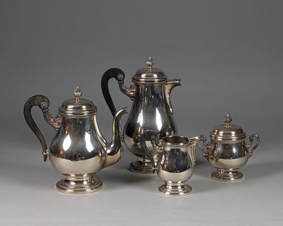 a silver tea set on a table next to other silver items