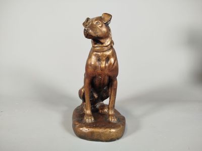 statue en bronze représentant un chien assis sur un socle en bois
