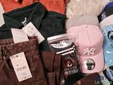 a pile of clothing that includes a baseball cap, shirt, pants, and other items
