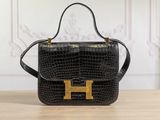 a black handbag with gold hardware on a wooden table