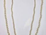 a white pearl necklace with a gold clasp and two strands of pearls